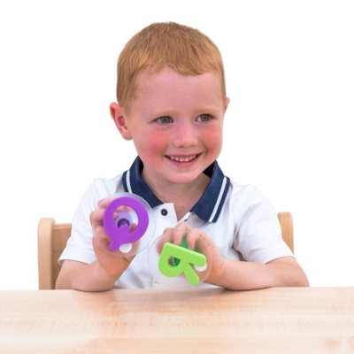 Criança sorridente com moldes de letras coloridas