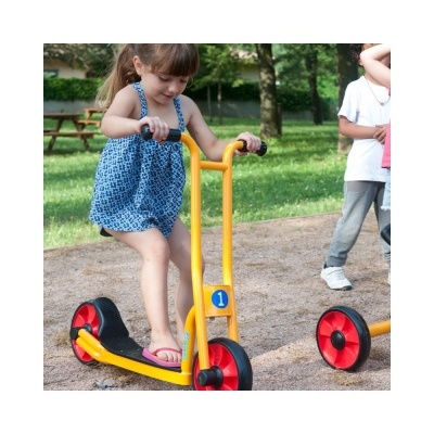 Criança a andar num trotinet amarelo com rodas vermelhas num parque