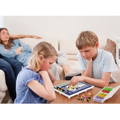 Crianças a jogar jogo de tabuleiro com peças coloridas numa sala de estar