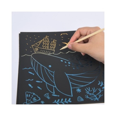 Folha preta com desenhos riscados coloridos de baleia, peixes, navio e corais