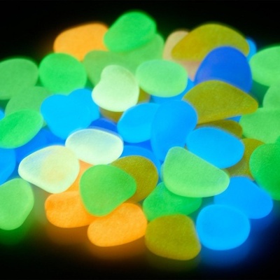 Pedras fluorescentes azuis, verdes, brancas e laranjas sobre fundo preto