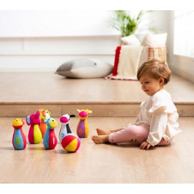 Criança brinca com conjunto de boliche colorido no chão de madeira