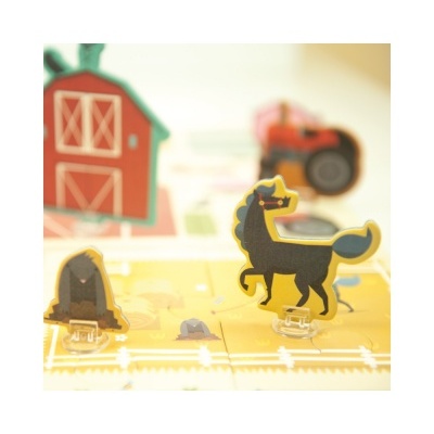 Miniaturas de cavalo e feno num tabuleiro de jogo agrícola com celeiro vermelho ao fundo