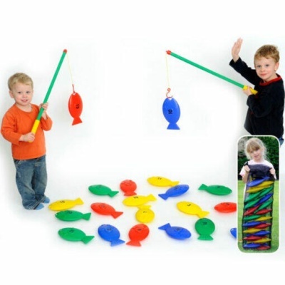 Crianças a brincar com jogo de pesca com peixes de plástico coloridos e varas de pesca