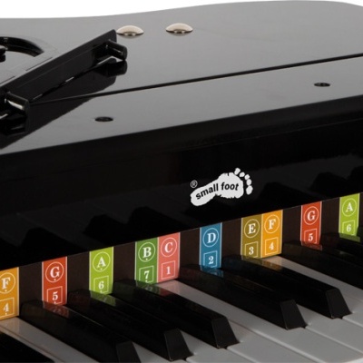 Pequeno piano de brinquedo preto com etiquetas coloridas nas teclas