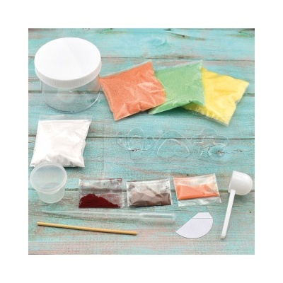 Conjunto de pigmentos em pó, frasco, colher e utensílios sobre mesa azul