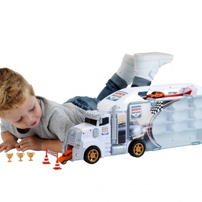 Carrinha de brinquedo branca com mini troféus e cones com menino a brincar