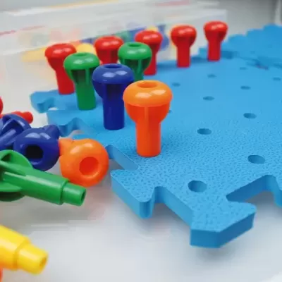 Peças de plástico coloridas para encaixar numa base azul
