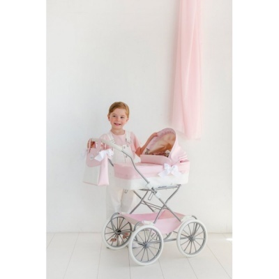 Carrinho de bonecas cor-de-rosa com menina e fundo branco com cortina cor-de-rosa