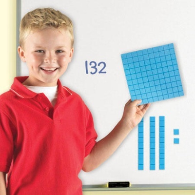 Menino com peças educativas azuis a ensinar matemática num quadro branco