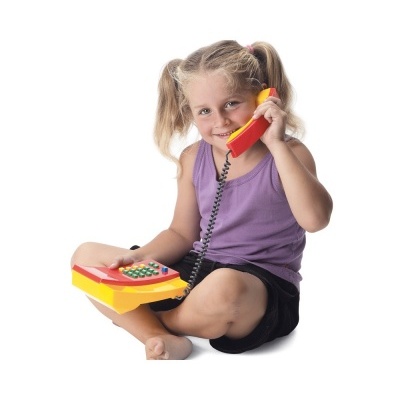 Menina loira sentada com telefone de brinquedo amarelo e vermelho