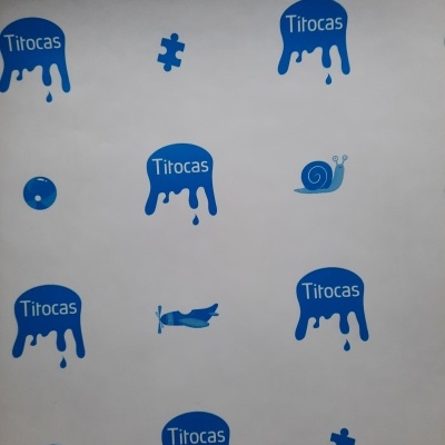 Pinturas azuis várias numa parede branca com a palavra Titocas e imagens de caracol, avião, puzzle, cubo com letras.