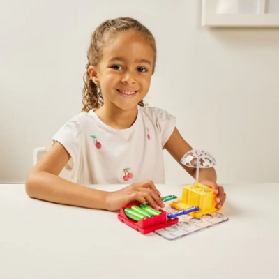 Criança a brincar com brinquedo colorido sobre mesa