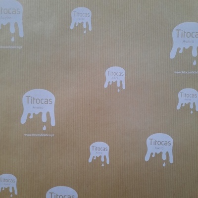 Papel de embrulho castanho com padrões brancos e texto Titocas Aveiro