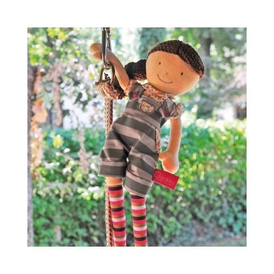 Boneca de pano com roupa às riscas pendurada em corda ao ar livre