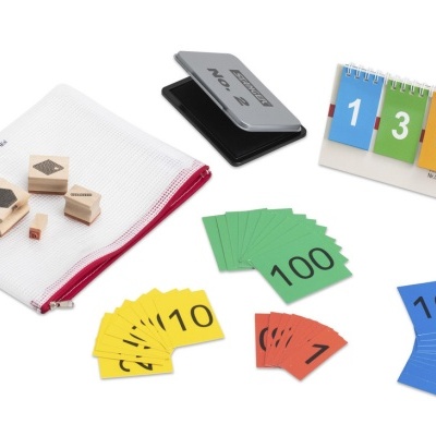 Cartas coloridas, carimbos de madeira, almofada de carimbo e calendário de mesa num fundo branco.