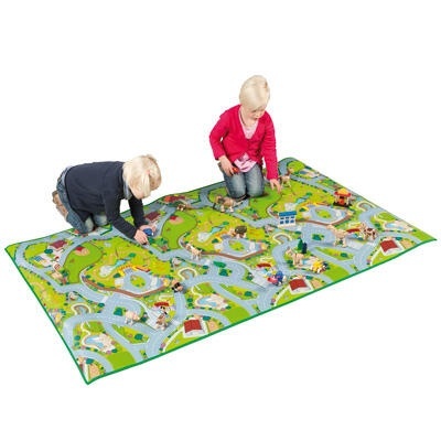 Crianças a brincar num tapete colorido com padrão de estrada e rios