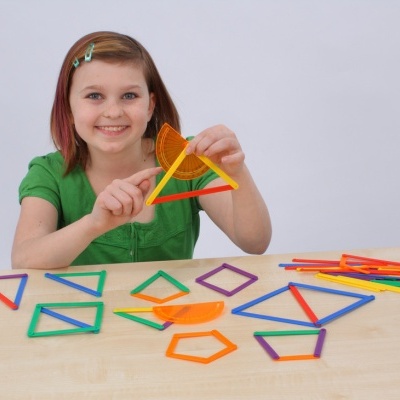 Menina segura transferidor laranja e triângulo com paus coloridos