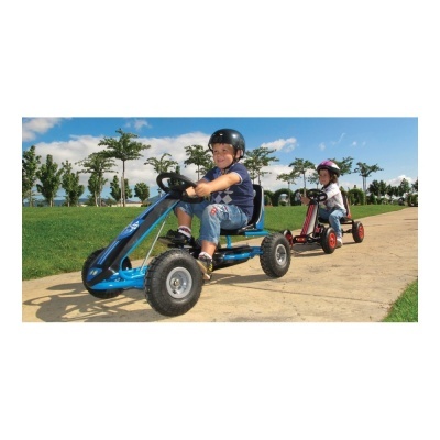 Crianças em karts manuais azul e vermelho com capacetes a andar numa passadeira