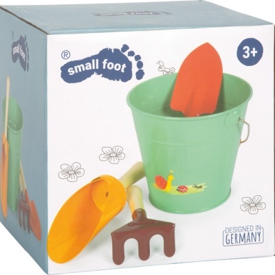 Conjunto de jardineiro infantil com balde verde, pá laranja e amarela, ancinho castanho, embalagem marca small foot.