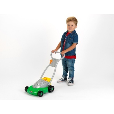 Criança com corta-relva de brincar verde e cinzento