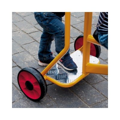 Trotinete infantil amarela com plataforma prateada e rodas vermelhas, criança em cima