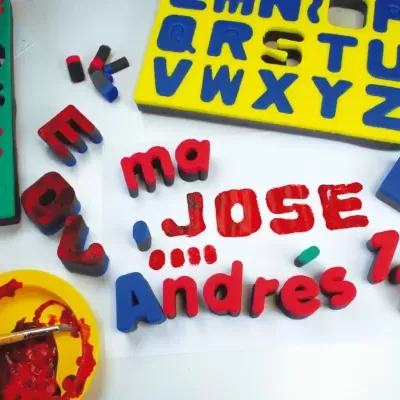 Letras de espuma coloridas e tintas para pintura em papel.