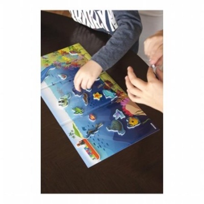 Mãos de uma criança e adulto a montar puzzle infantil temático marinho sobre mesa escura