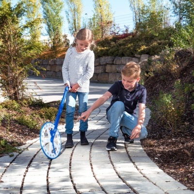 Medidor de distância azul com roda numerada em caminho de pedra ao ar livre