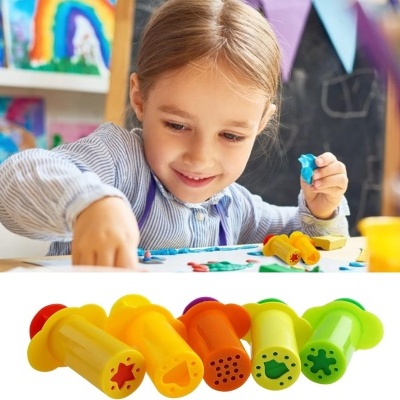 Conjunto de carimbos plásticos coloridos com formas recortadas e criança com massa de modelar azul