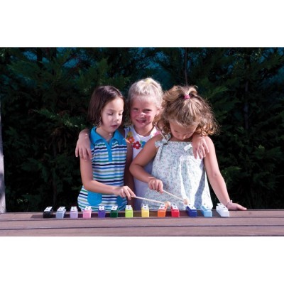 Três meninas a tocar xilofone colorido de madeira ao ar livre