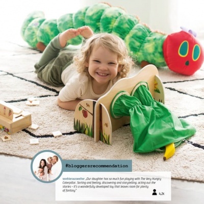 Criança a brincar com brinquedos coloridos num tapete claro.