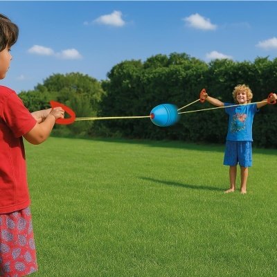 Crianças brincando com brinquedo de corda e esfera azul ao ar livre