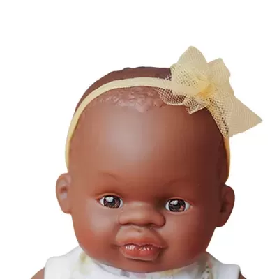 Boneca bebé com fita amarela com laço e vestido branco com flores amarelas