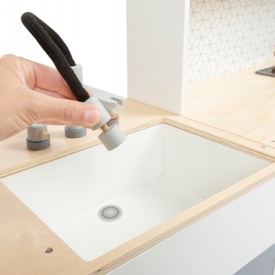 Cozinha de brinquedo em madeira clara com pia branca e torneira cinza