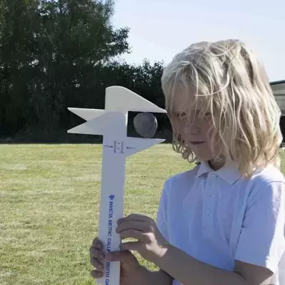 Criança com calibrador métrico branco grande em campo gramado