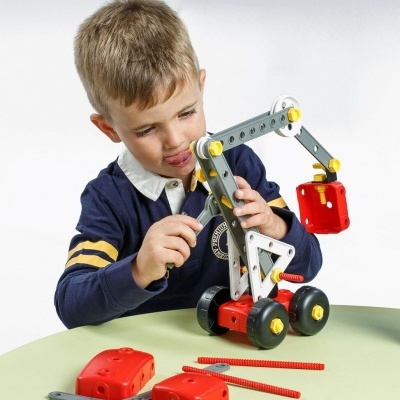 Criança a construir brinquedo de construção colorido numa mesa