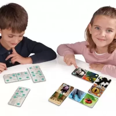 Crianças a jogar dominó com peças coloridas com pontos verdes e imagens de animais