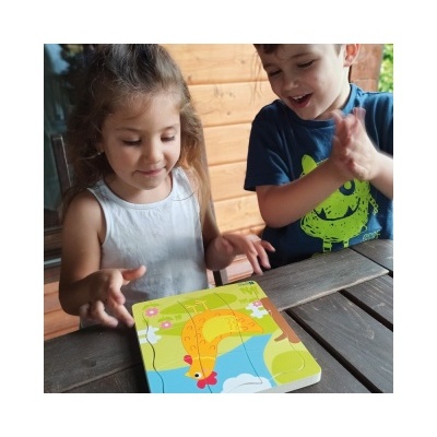 Crianças a montar um puzzle de madeira com imagem de girafa colorida