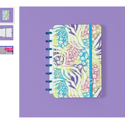 Caderno colorido com elástico azul sobre fundo roxo