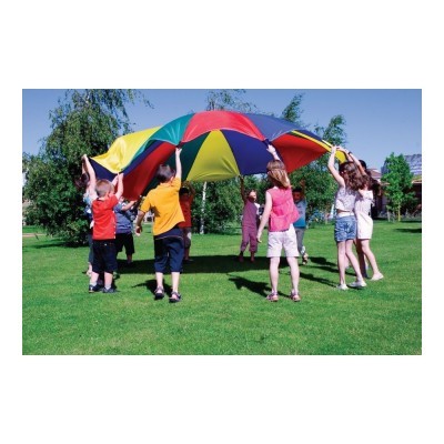 Crianças segurando tecido multicolorido em campo verde