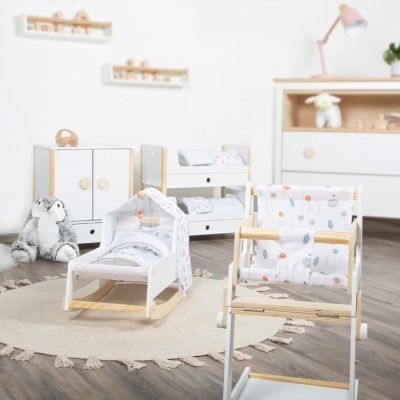 Conjunto de móveis infantis em madeira clara e branca com padrão de bolinhas coloridas