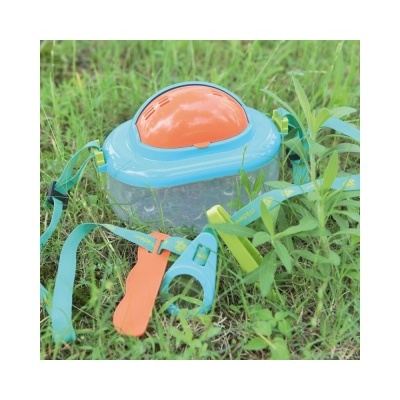 Brinquedo infantil com recipiente transparente e tampa laranja e azul na relva