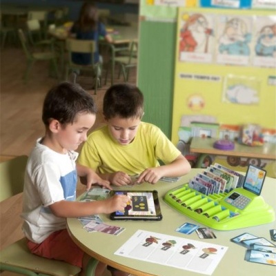 Crianças a jogar jogo educativo numa sala de aula colorida.