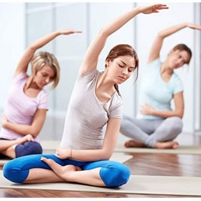 Mulheres a praticar yoga num estúdio com roupa confortável azul, rosa e cinzenta.