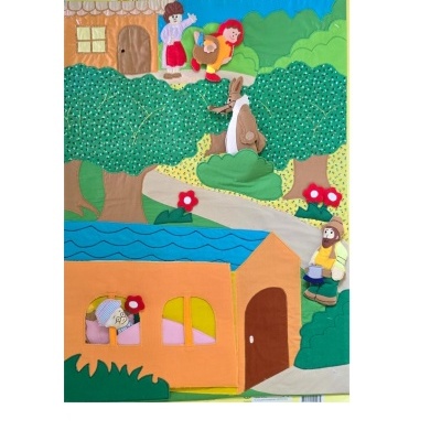 Parede de tecido colorido com personagens da história do Capuchinho Vermelho e elementos naturais e de casa.