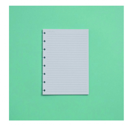 Folha de papel pautada branca com orifícios sobre fundo verde