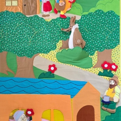 Painel educativo de tecido com cenário e personagens coloridos