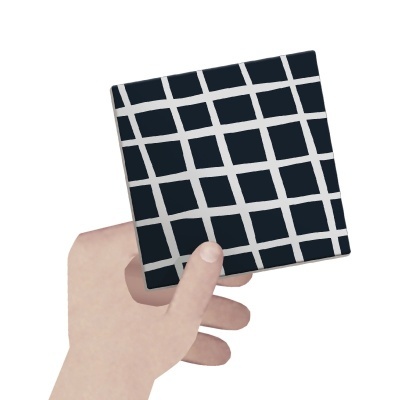 Mão a segurar objeto quadrado com padrão preto e branco