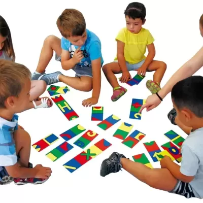 Crianças a jogar com cartas coloridas e letras num chão branco